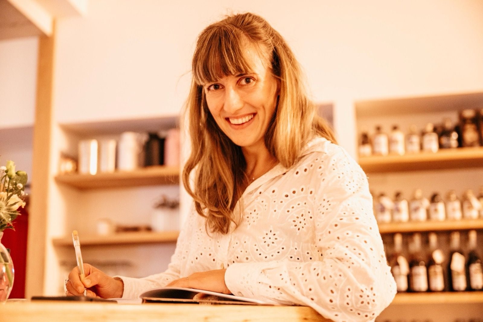 Jule Mohr am Tisch, mit Stift und aufgeschlagenem Heft